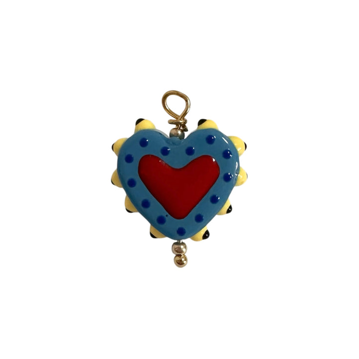 A heart-shaped enamel charm with a red center, blue outer border, yellow spikes.