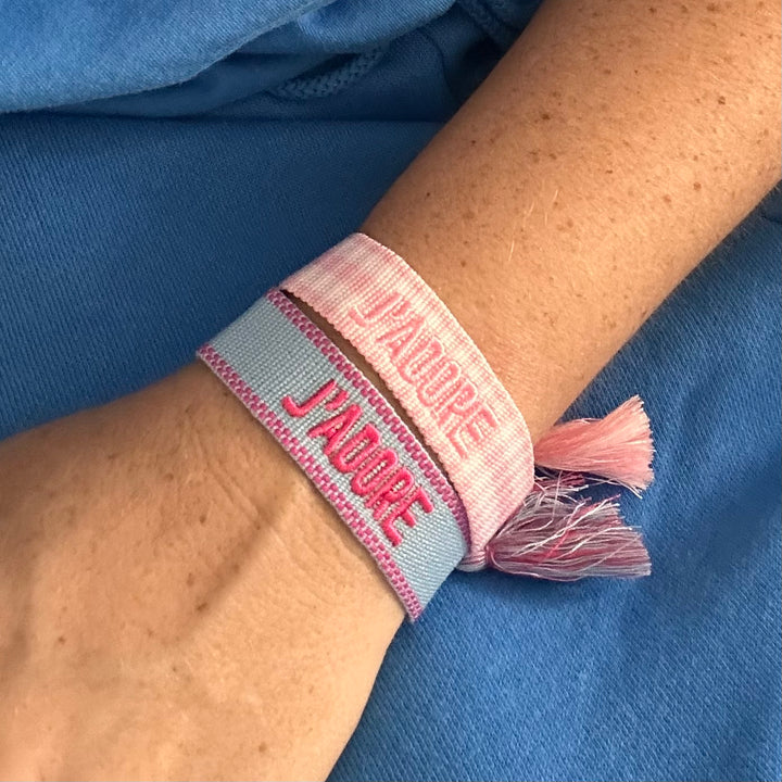 Pink and sky blue woven cotton bracelets stacked on the wrist, pink French embroidery and tassel ties – La Maison Angélique Dubai